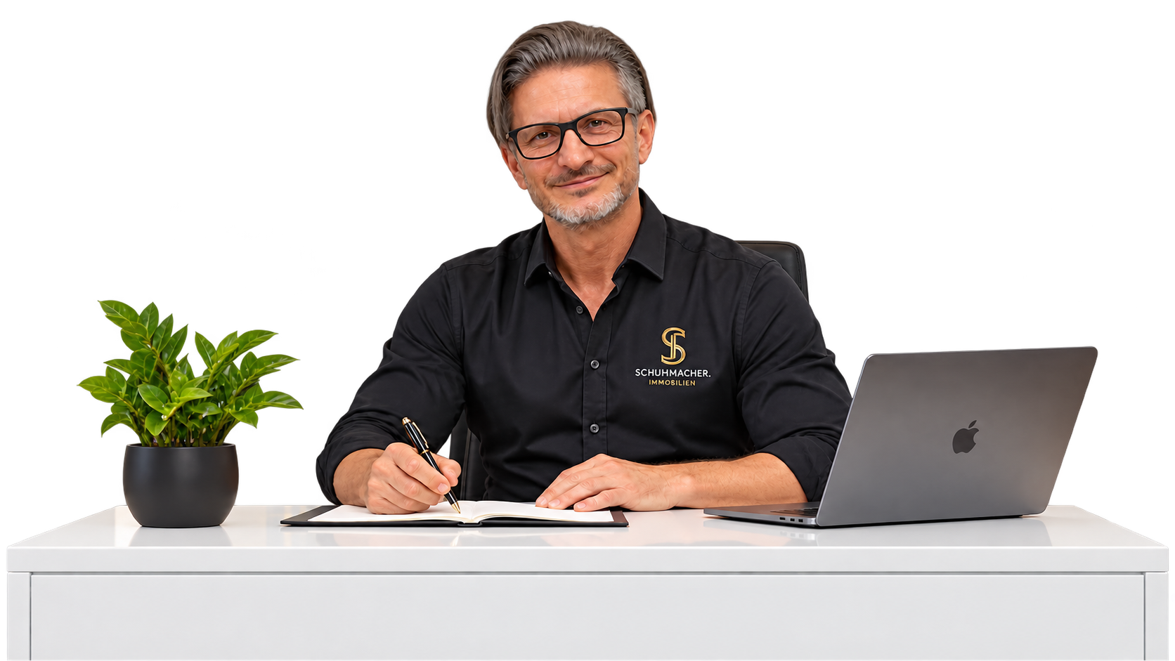 Kai Schuhmacher am Schreibtisch mit Laptop und Notizbuch